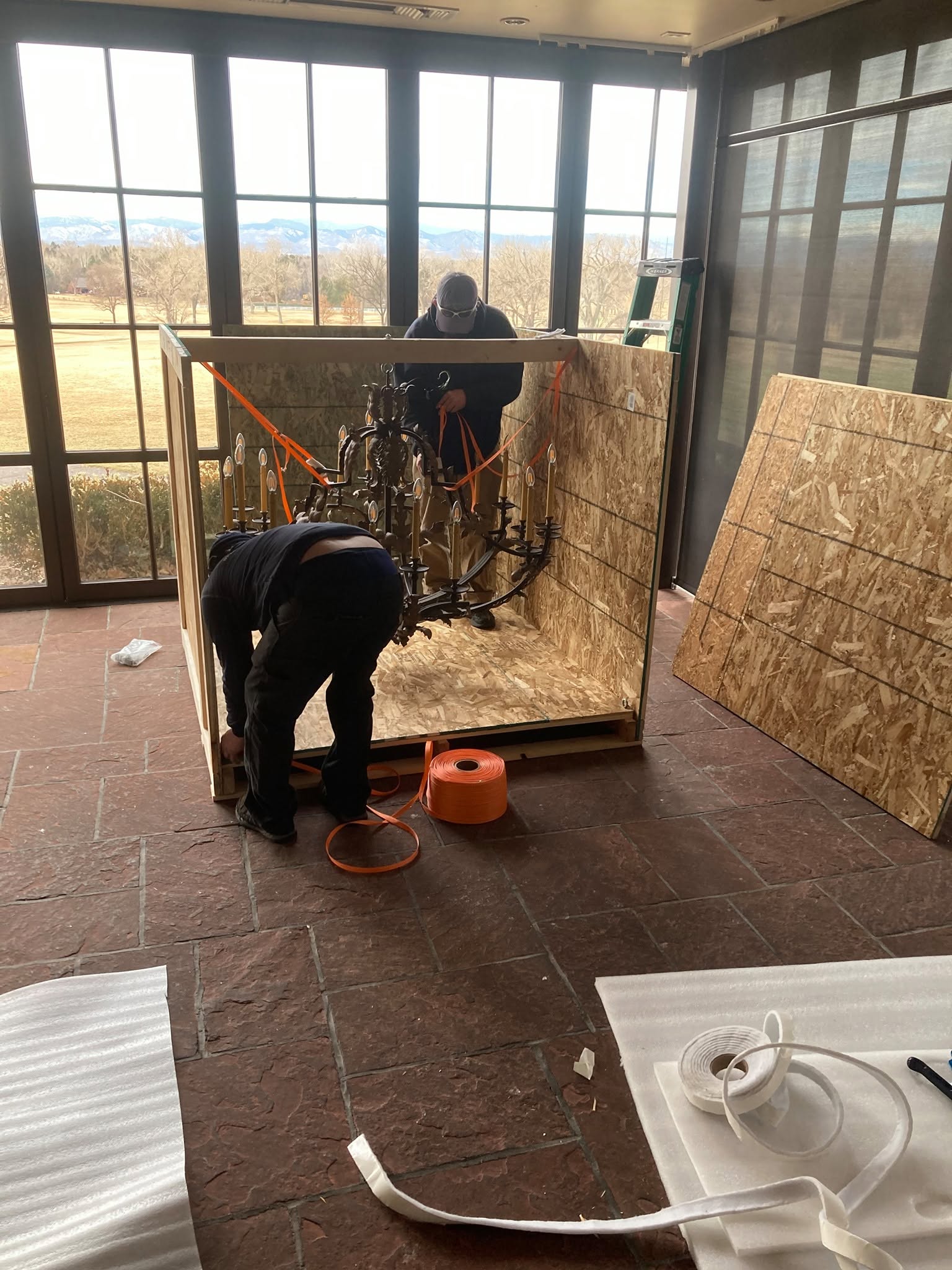 Technicians securing a chandelier inside a custom crate on-site